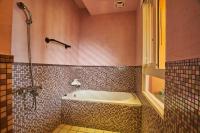 a bathroom with a bath tub and a shower at Sharjah B&amp;B in Wujie
