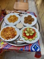 Una mesa con platos de comida sobre una mesa. en Kashta Nubian Guest Houst, en Asuán