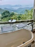 a bath tub sitting in front of a large window at Sunny Room in Jiufen