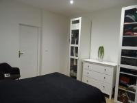 - une chambre avec un lit, une commode et un placard dans l&#39;établissement Appartement Artem neuf et terrasse, à Nancy