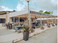 een restaurant met tafels en stoelen voor een gebouw bij Ohana Cottage in Fréjus