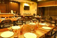 a restaurant with wooden tables and chairs with empty plates at ISORA RESORT Puerto Galera in Puerto Galera