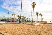 a beach with palm trees and a parking lot at Pavillon de Mer YourHostHelper in Vallauris