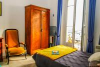 a bedroom with a bed and a chair and a cabinet at Pavillon de Mer YourHostHelper in Vallauris