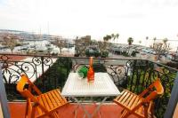 a table and chairs on a balcony with a view of a harbor at Pavillon de Mer YourHostHelper in Vallauris