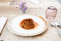 a white plate with some pasta on a table at La Maison Rosa Stella in Lucera