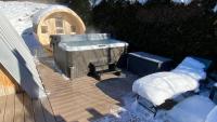 a hot tub on a deck in the snow at Au-Doux-Altic chalet romantique avec JACUZZI ET SAUNA in Métabief