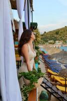a woman in a white dress standing next to plants at Nili Deluxe in Sarandë