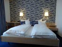 Un dormitorio con una cama grande con dos almohadas. en Hotel Bündnerhof, en Davos