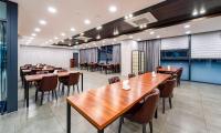 a dining room with wooden tables and chairs at Golden Tulip Essential Namgang in Jinju