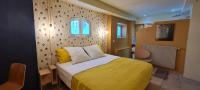 ein Schlafzimmer mit einem Bett mit einer gelben Decke in der Unterkunft Villa Aigarden maison d&#39;hôtes in Avignon