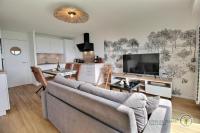 a living room with a couch and a large television at La plage in Trébeurden