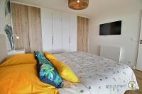 a bed with pillows on it in a bedroom at La plage in Trébeurden