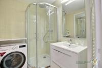 a bathroom with a shower and a washing machine at La plage in Trébeurden