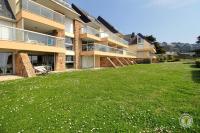 a large grassy yard in front of a building at La plage in Trébeurden