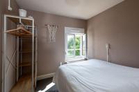 a bedroom with a white bed and a window at le Guydine 