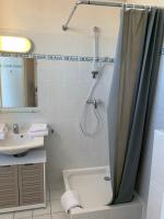 a bathroom with a shower curtain and a bath tub at Résidence Le Rochebonne in Saint Malo
