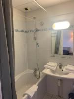 a bathroom with a tub and a sink and a mirror at Résidence Le Rochebonne in Saint Malo