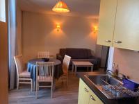 a kitchen and living room with a table and a couch at Résidence Le Rochebonne in Saint Malo