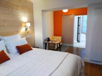 a bedroom with a large bed with an orange wall at Les Balcons sur la Loire in Chalonnes-sur-Loire