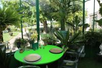 a green table in a garden with plants at Taty Ginette Maison et Table d'Hôtes in Marolles