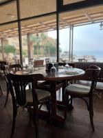 een restaurant met tafels en stoelen en een groot raam bij E25 TWO BEDROOM APARTMENT AT Samarah Resort in Sowayma