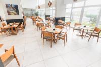 Un comedor con mesas y sillas de madera. en Silverton Paiva Experience, en Recife