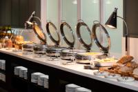 Una línea de buffet con comida, pan, ollas y sartenes. en Mercure Sydney Macquarie Park, en Sídney