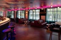 シドニーにあるibis Styles Sydney Centralのピンクの照明がついた部屋にソファと椅子が置かれたバー