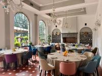 a dining room with tables and chairs and chandeliers at Fantastic Garden - Firenze Nord in Sesto Fiorentino