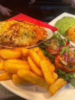 ヨークにあるThe Manor Inn Pub and Steakhouse, Fridaythorpe, Driffieldの魚とフライドポテトを盛り付けた料理