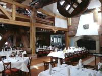 une salle à manger avec des tables et des chaises blanches ainsi qu'une cheminée dans l'établissement Dom w Starym Parku, à Biskupice