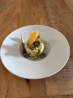 un plato blanco con comida en una mesa de madera en LOGIS Hôtel & Restaurant - Le Manoir de Gavrelle, en Gavrelle