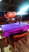 a wooden table with a purple table cloth on it at Dreamer Resort in San Vicente