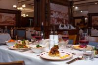 una mesa con platos de comida y copas de vino en MPM Hotel Sport Ski-in, Ski-out, en Bansko