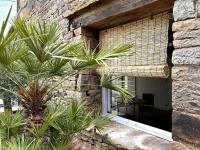 a stone building with palm trees in front of a window at La maison Léopoldine 
