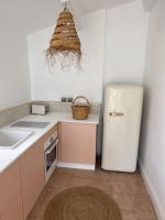 a kitchen with a refrigerator and a basket on the wall at La maison Léopoldine 