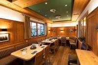 un restaurante con mesas y sillas y techo verde en Haller's Posthotel, en Riezlern