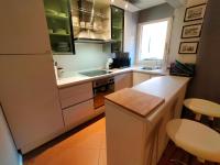 a kitchen with green cabinets and a white refrigerator at Bel appartement hyper centre, direct plage. in Sainte-Maxime