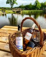 uma cesta de garrafas e taças de vinho sobre uma mesa de piquenique em Dwór Sulejów em Sulejów