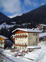 un gran edificio en la nieve con una montaña en Pension Bichlgeiger, en Anras