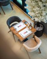 una mesa y una silla en una habitación con una mesa y una mesa en Ward Hotel Basra, en Basora