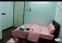 Una cama rosa con un gato sentado encima. en Rent Room, en Ipoh