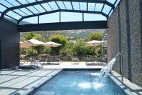 - une piscine avec une fontaine, des tables et des parasols dans l&#39;établissement Domaine Villas Mandarine Private Pools &amp; Spa, à Calvi