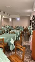 Un comedor con mesas verdes y sillas de madera. en HOTEL RISTORANTE SAN GIOVANNI, en Falerna