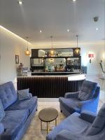 ein Wohnzimmer mit zwei blauen Sofas und einer Bar in der Unterkunft Canterbury Cathedral Lodge in Canterbury