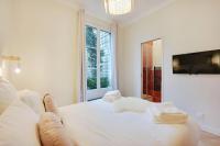 a bedroom with a white bed with towels on it at Comfy Suite by Les Maisons de Charloc Homes in Boulogne-Billancourt