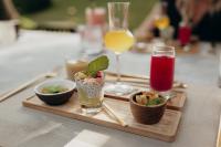 un tavolo con un vassoio di cibo e un bicchiere di succo di East Bali Volcano View Resort & Spa - Adults Only Area a Karangasem