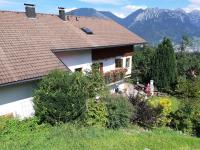 a house with a roof with mountains in the background at Landhaus Berthold in Bürserberg