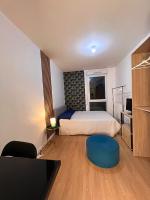 a small bedroom with a bed and a blue stool at SSP Suites- Cosy &amp; Bel appartement 4 pièces 3 chambres 90M2 avec balcon in Épinay-sur-Seine